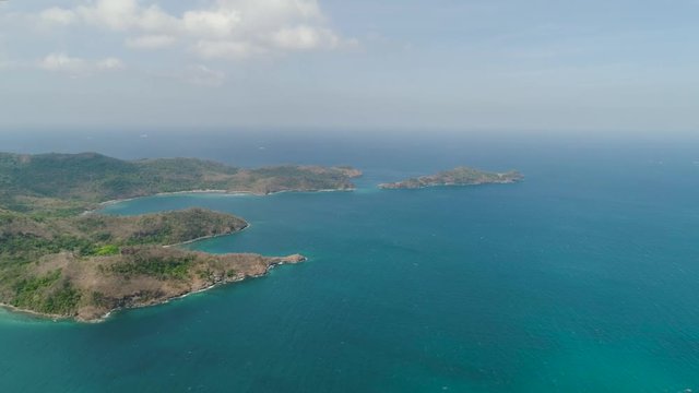 Aerial view of coast with beaches, island Limbones, lagoons and coral reefs. Neela cove, Philippines, Luzon. Coast ocean with turquoise water. Tropical landscape in Asia.