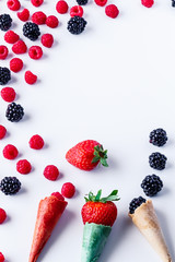 Frame isolated of Composition of fresh summer fruit, raspberries, blackberries, Strawberry and Cones on white background. Mediterranean diet with varied summer fruits. Stock photo. Top View