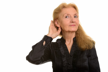 Studio shot of senior businesswoman listening