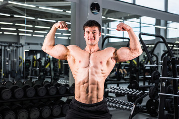 Fototapeta na wymiar Handsome bodybuilder man with big muscles in the gym
