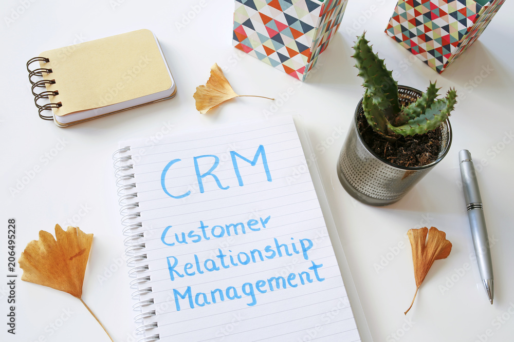 Poster crm customer relationship management written in notebook on white table