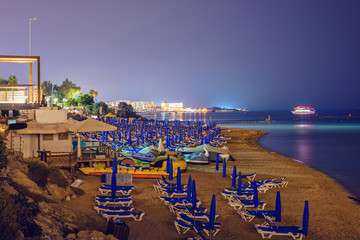 Fototapeta na wymiar Night view to beach and city with glowing lights