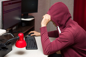 Internet troll using the computer. Bad young man writing nasty things on the forum 