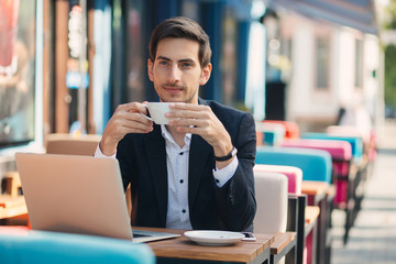 Young handsome man enjoy coffee working on laptop