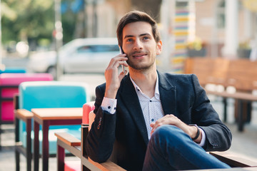 Portrait of young smiling businessman talking on the phone