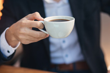 Close-up hand businessman holding cup
