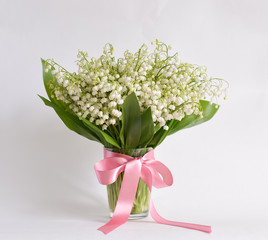 bouquet lily-of-the-valley stands on isolated background in mug with water
