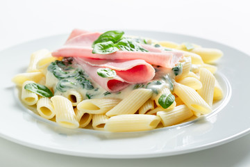 Hot pasta with bechamel sauce, ham and spinach