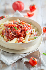 Spicy penne bolognese with bacon and herbs