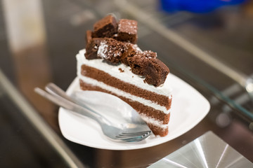 Chocolate cake and white cream on table