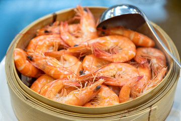 Shrimps heap boiled with scoop in wooden basket