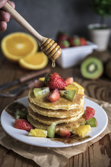 Buckwheat pancakes with berry fruit and honey.
