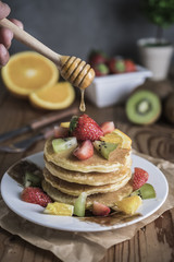 Buckwheat pancakes with berry fruit and honey.