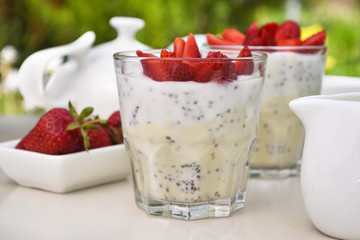 Summer breakfast in a garden. Strawberry chia pudding in glasses. 