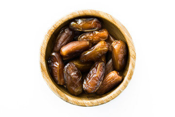 Dates food in wooden bowl isolated on white background. Top view