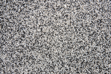 Gray and white small pebbles make up a beautiful building, facade texture