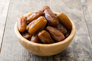 Dates food in wooden bowl on wooden table
