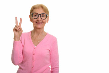 Happy senior nerd woman smiling and giving peace sign
