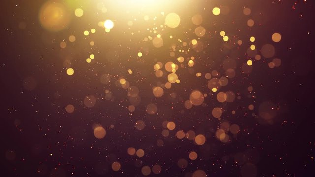 Abstract glittering gold with bokeh and dust effect . Black background .