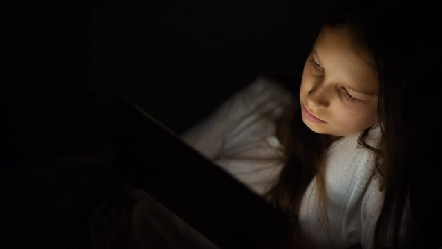 gadget night sleeplessness, caucasian girl chatting playing serfing network, bedtime playing with tablet in bed