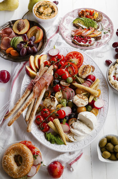 Variety of snacks prepared for picnic wine summer party with fresh fruits, vegetables, prosciutto and chesse