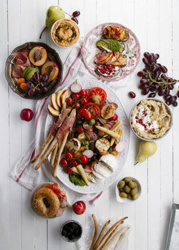 Variety of snacks prepared for picnic wine summer party with fresh fruits, vegetables, prosciutto and chesse