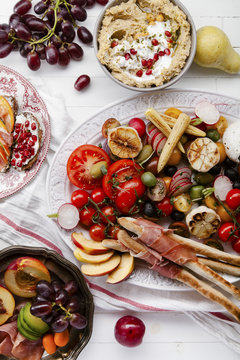 Variety of snacks prepared for picnic wine summer party with fresh fruits, vegetables, prosciutto and chesse