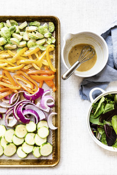 Lemon dijon dressing with a tray of vegetables to be baked