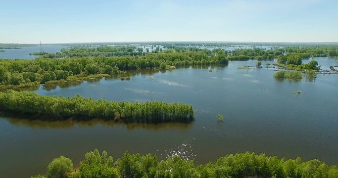 Aerial video of a big lake and a flooded river. Drone moving forward. Aerial stock footage shot at summer season time.