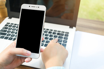 Close-up of Business woman working with smartphoneat,laptop and document.