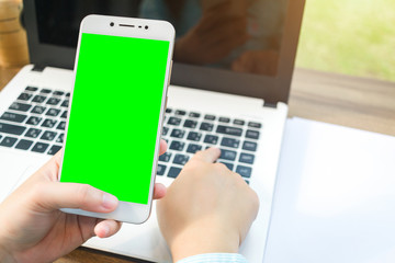 Close-up of Business woman working with smartphoneat,laptop and document,green screen