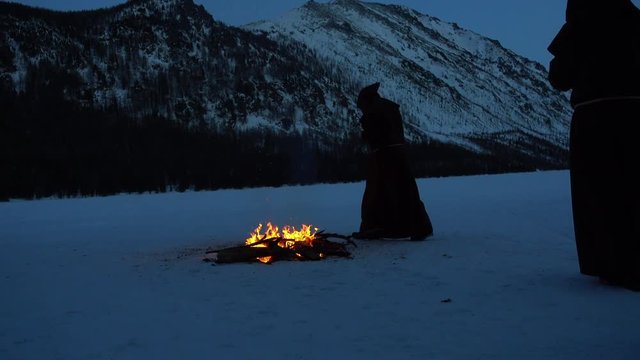 Four monks meditates next to the campfire