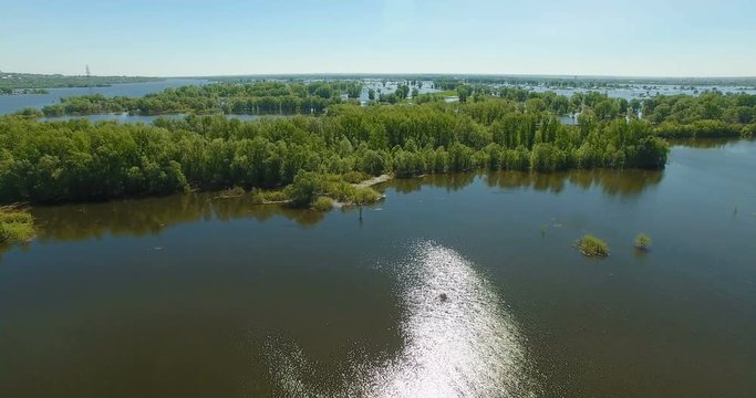 Aerial video of a big lake and a flooded river. Drone moving forward. Aerial stock footage shot at summer season time.
