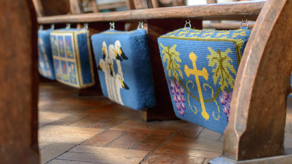 Embroidered Kneelers Prayer Cushions Hanging From Church Bench, shallow depth of field - 206512647