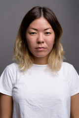 Young beautiful Kazakh woman against gray background