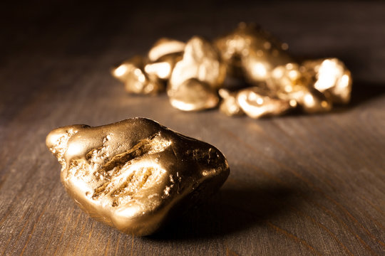 golden nuggets on wooden table