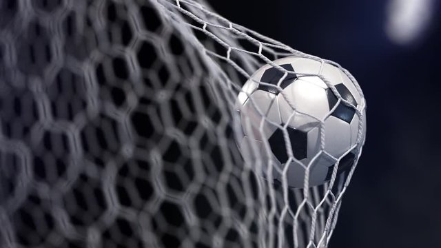 Beautiful soccer ball flies into net. Projector of light on a background. The movement at the beginning is accelerated then slowly