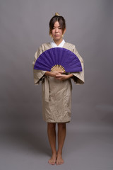 Young beautiful Kazakh woman against gray background