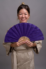 Young beautiful Kazakh woman against gray background