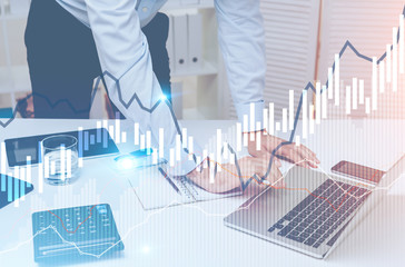 Man hand typing in office, graphs