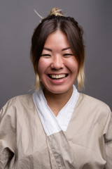 Young beautiful Kazakh woman against gray background