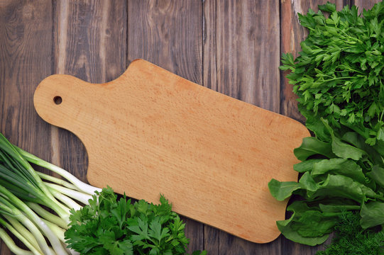Healthy vegan cooking concept. A bunch of parsley / cilantro on a wooden background. Fragrant greens on the boards.