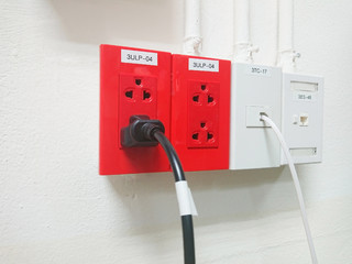 red electrical outlet installed on white wall