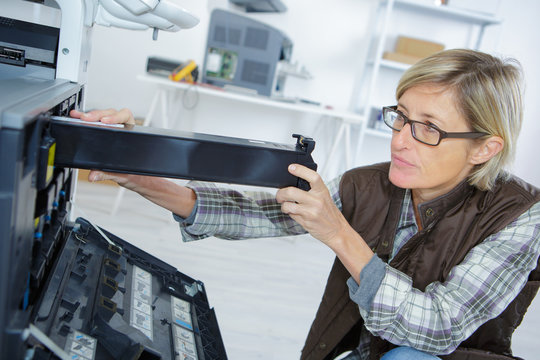 female technician fixing the office printer