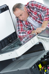 printer checking a print run at table
