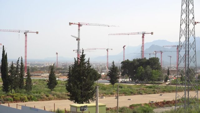 panorama of cranes over building construction at dawn