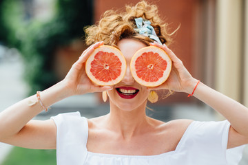 Woman fit girl holding two halfs of grapefruit