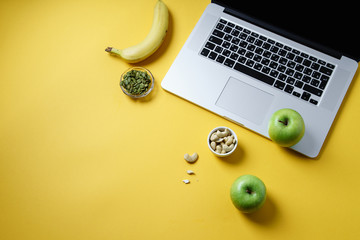 Overhead flatlay image with notebook and healthy snacks on colorful background with copy space....