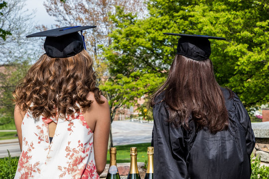 Two senior college students viewed from the back are ready to celabrate the graduation day