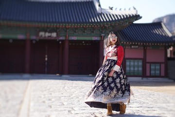 Fashion Portrait of young Asian Beauty girl in Hanbok traditional Korean clothes in autumn winter at the Gyeongbokgung Palace, Seoul, South Korea